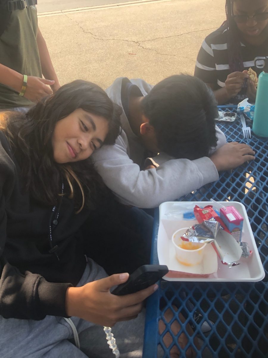 Students Janessa Hallman (left) and Liam Acelar (Right) relax during lunch by talking and going on social media