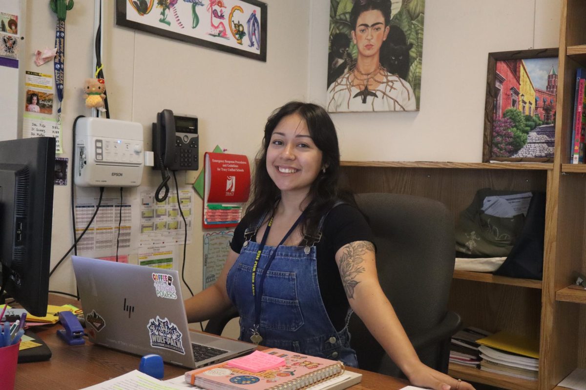 Ms. Ortega, a new Spanish teacher at West, poses at her desk in P-9.